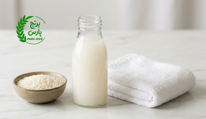 بطری آب برنج خانگی برای روتین مراقبت پوست روی پس‌زمینه روشن